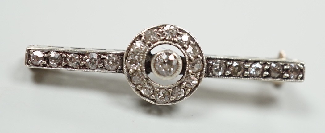 An early 20th century 9ct white metal diamond target cluster set bar brooch, 30mm, gross weight 2.5 grams.